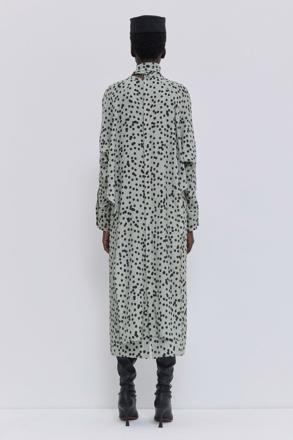 Back view of a sage printed midi dress with batwing sleeves, scarf collar and elegant straight silhouette by Christian Wijnants.