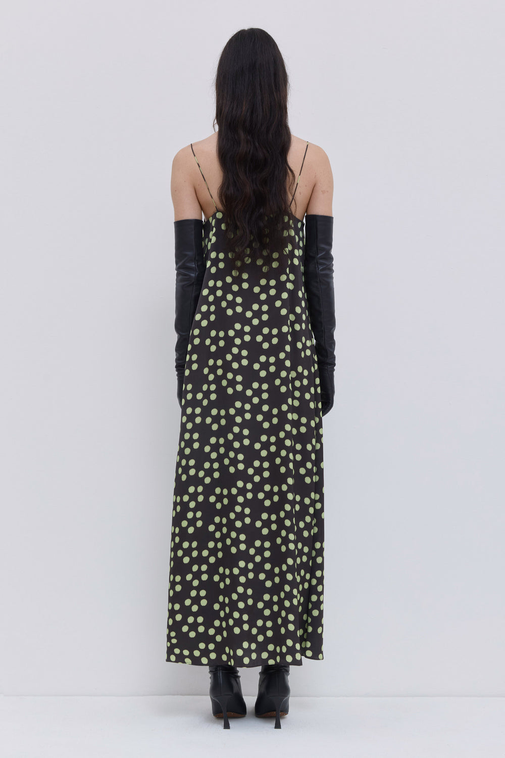 Back view of a dark forest penny maxi dress with slim straps, fluid A-line silhouette and scattered dot print by Christian Wijnants.