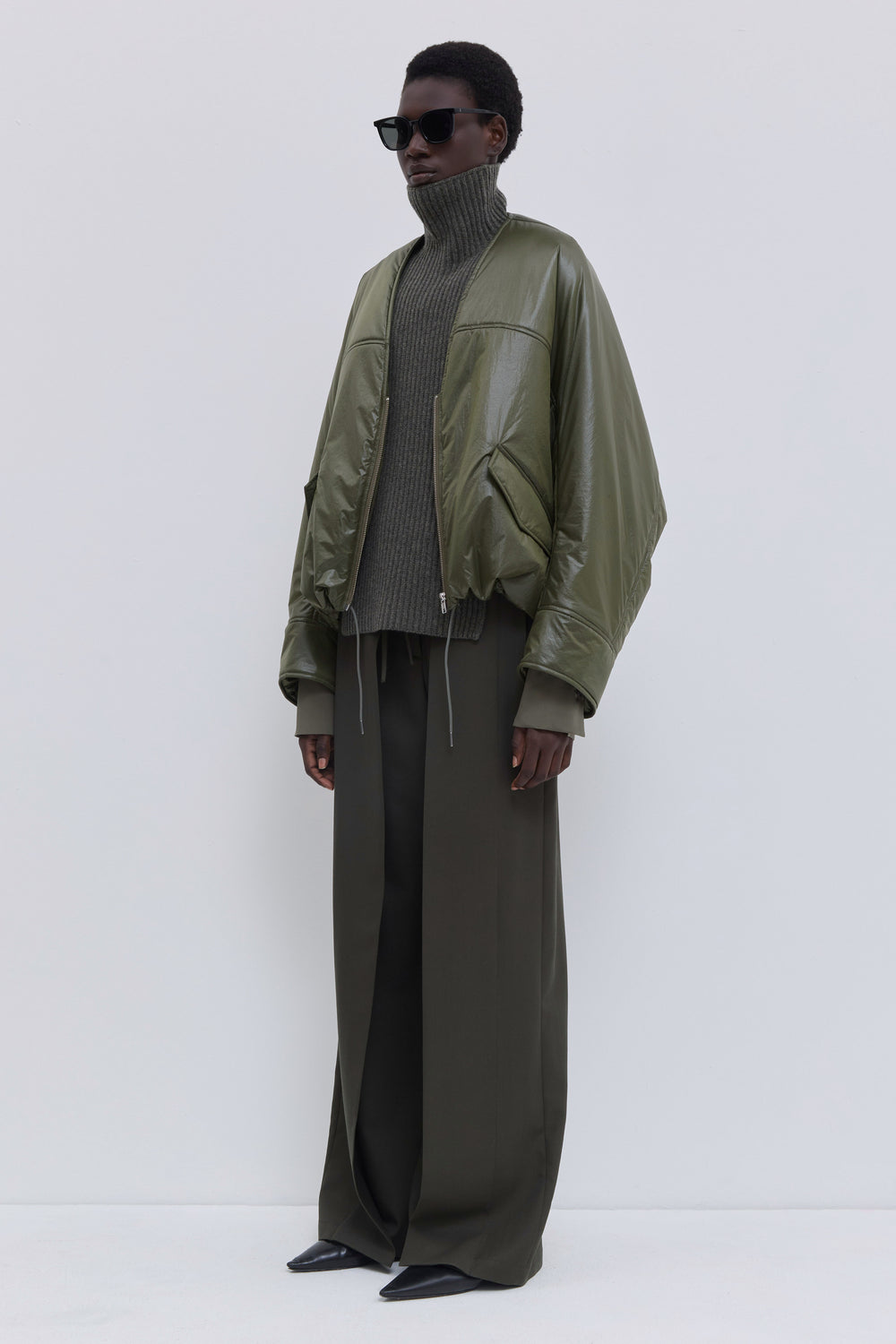 Side view of the Jelana olive padded jacket with sculptural sleeves.