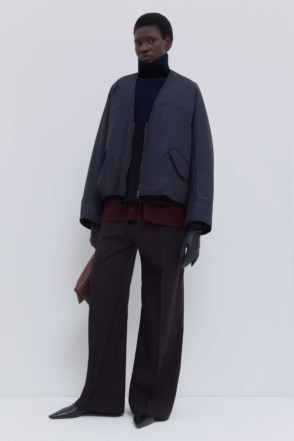 Side view of the Jelana lightweight padded jacket in navy oil with oversized sleeves and water-repellent finish.