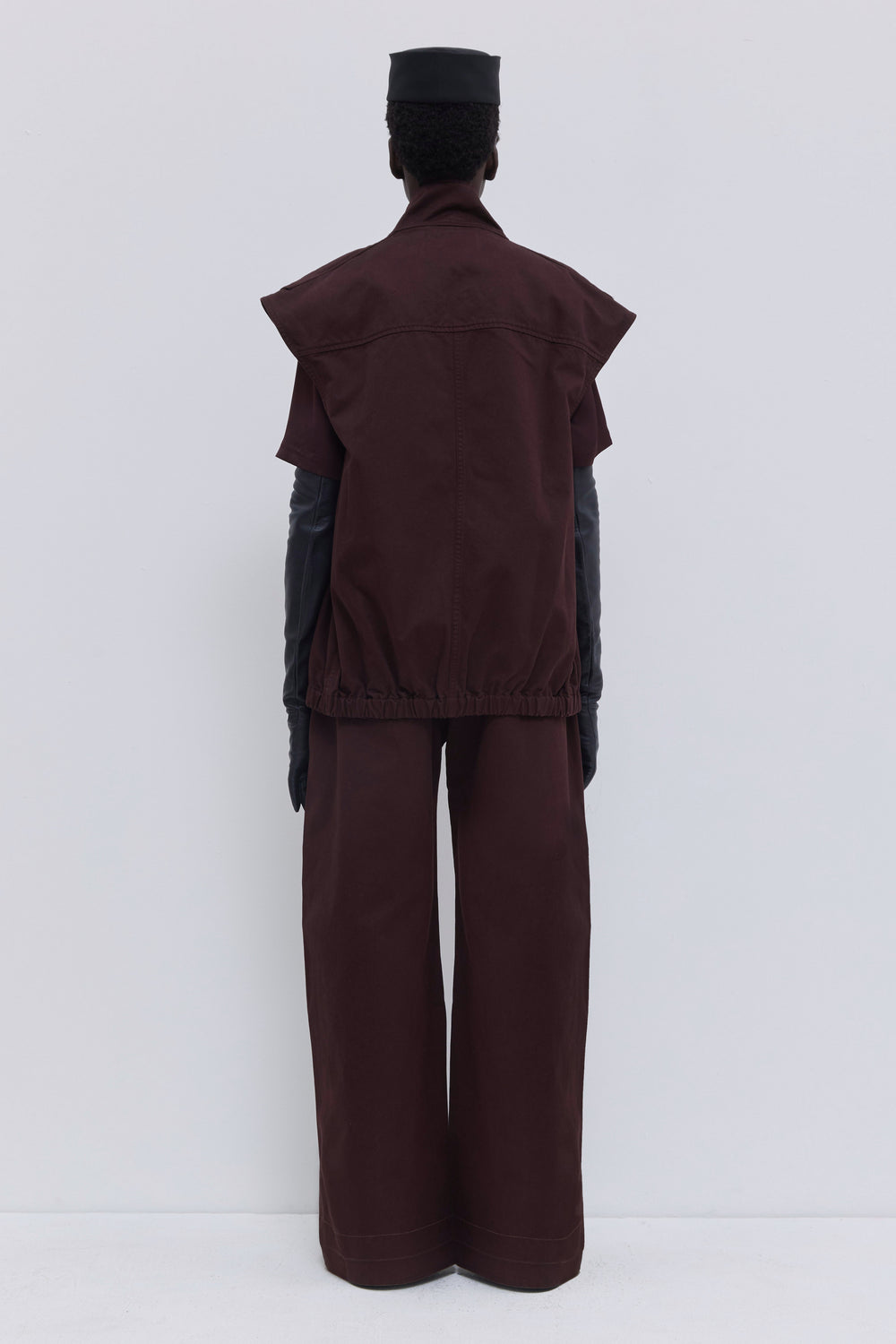 Back view of the Jupi sleeveless jacket in plum garment-dyed organic cotton with oversized shoulders and clean tailored finish.