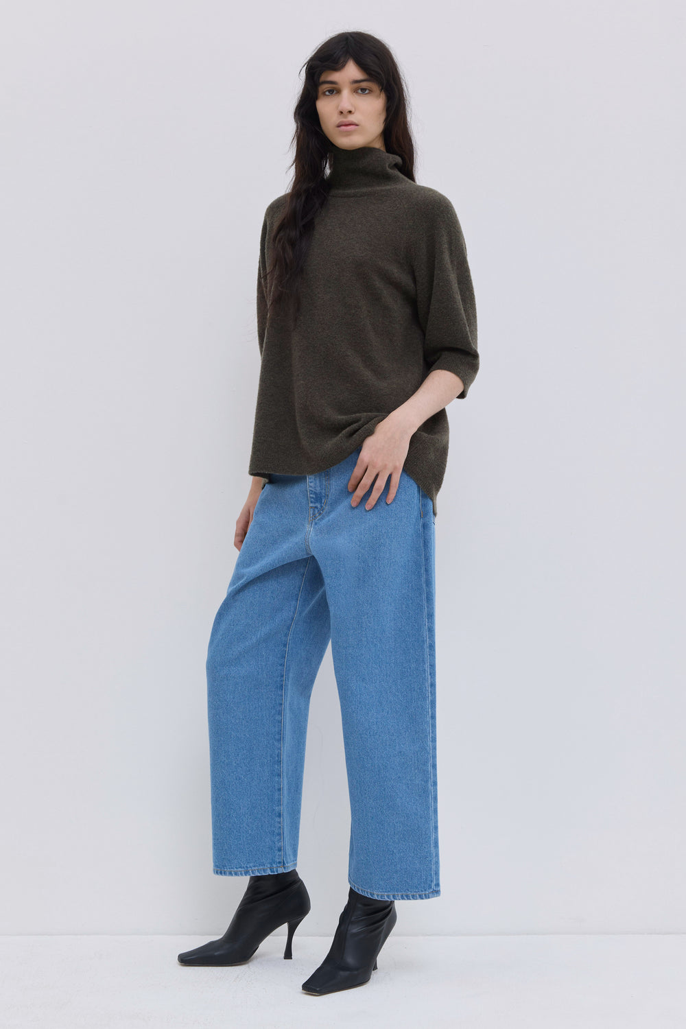 Front view of a luxurious forest short-sleeve turtleneck knit in soft bouclé yarn.