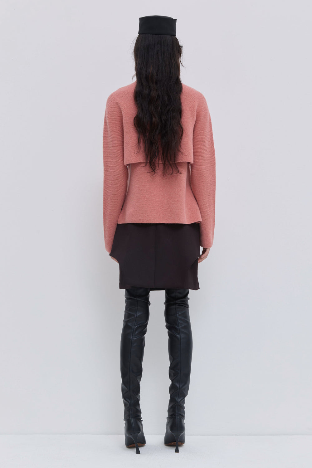 Back view of coral turtleneck sweater in seamless knit construction