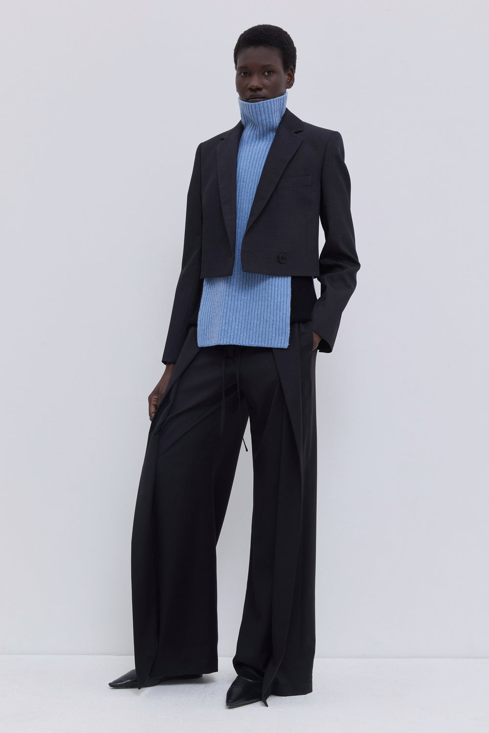 Mirage blue ribbed merino wool and cashmere knit bib layered beneath a matching ribbed zip-up cardigan with tailored wide-leg trousers.