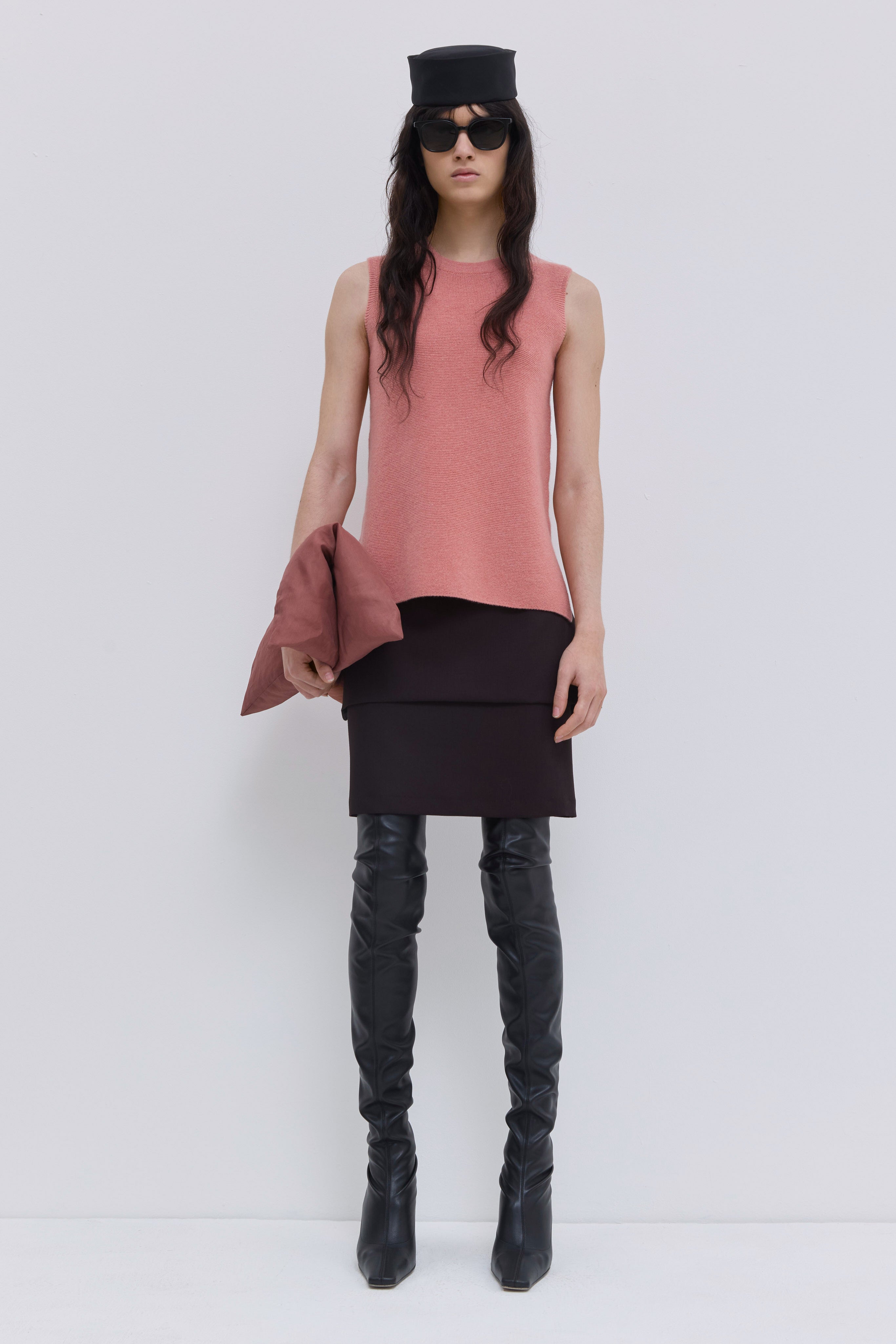 Coral sleeveless wholegarment knit top with round neckline and side slits.