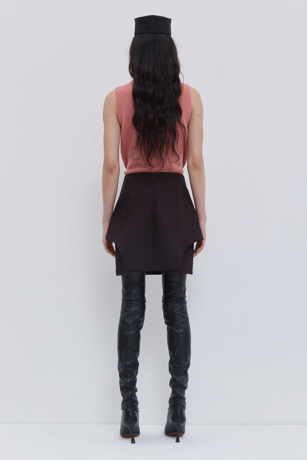 Back view of a coral wholegarment knit top with clean minimalist silhouette.