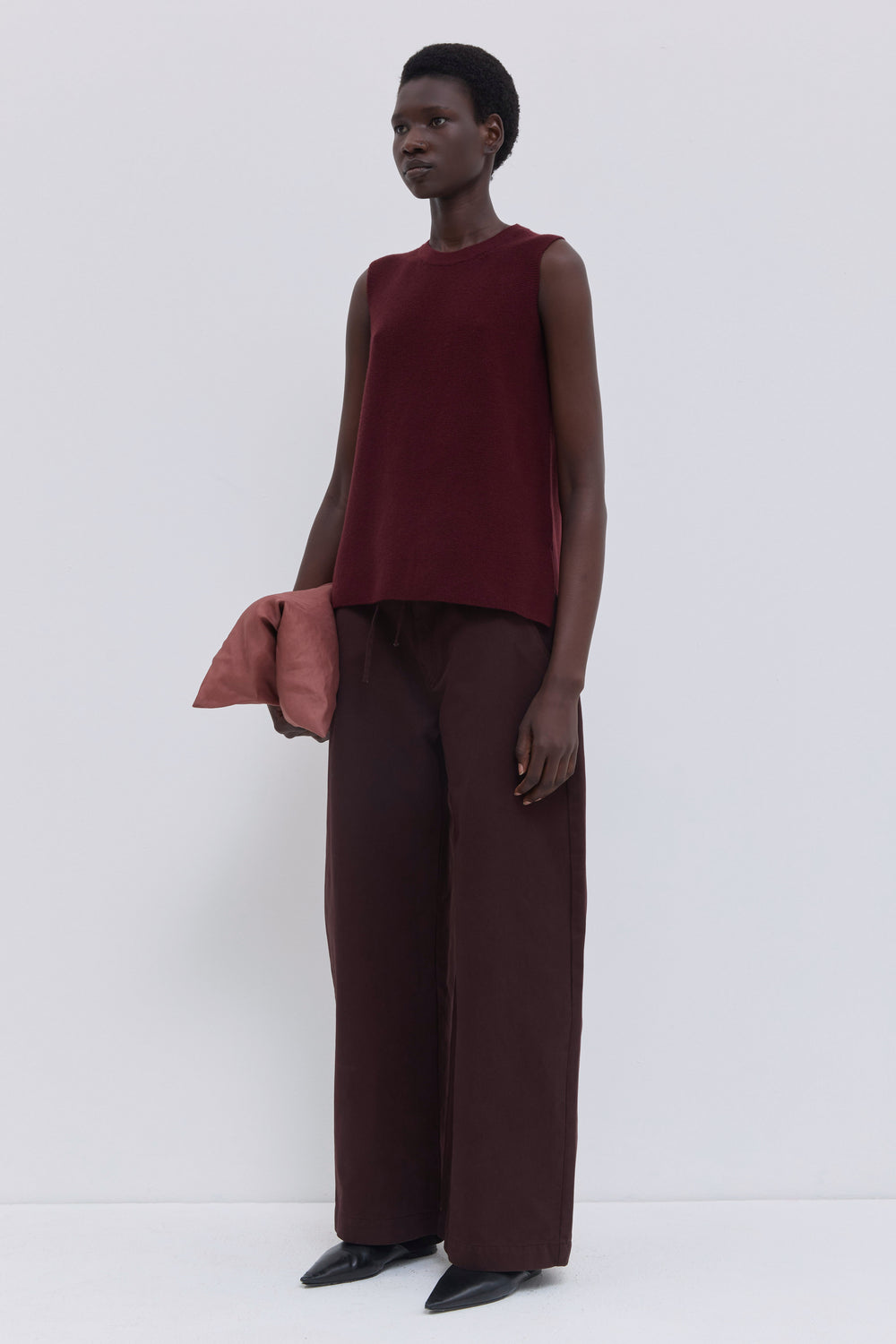 Front view of a garnet seamless sleeveless knit top with a relaxed fit.