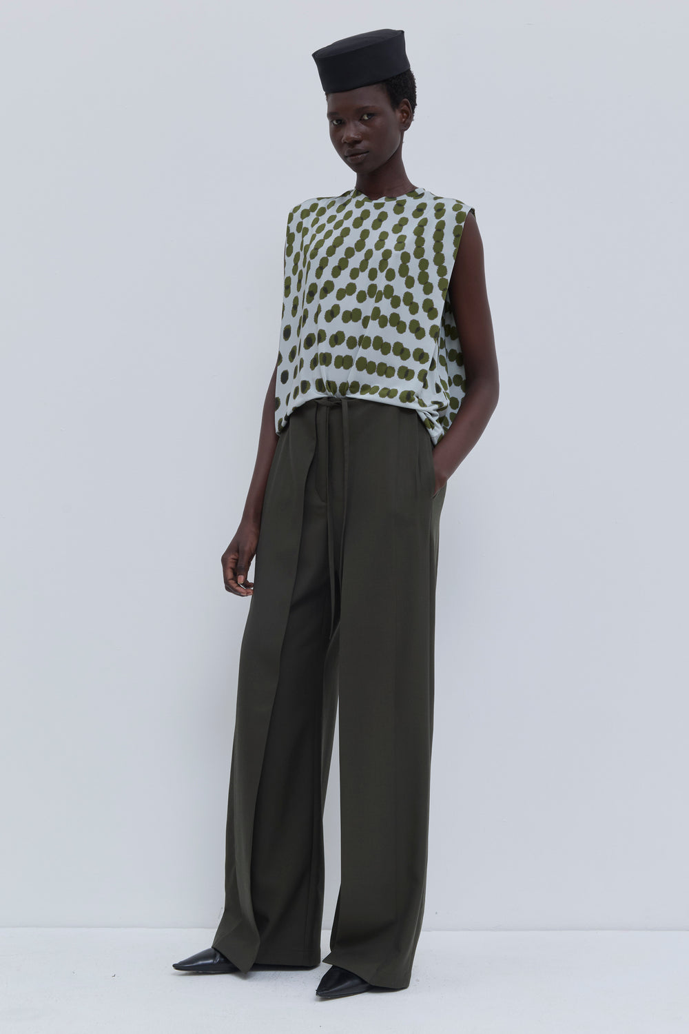 Side view of the Paire wide-leg trousers in Deep Forest styled with a printed long sleeve top.