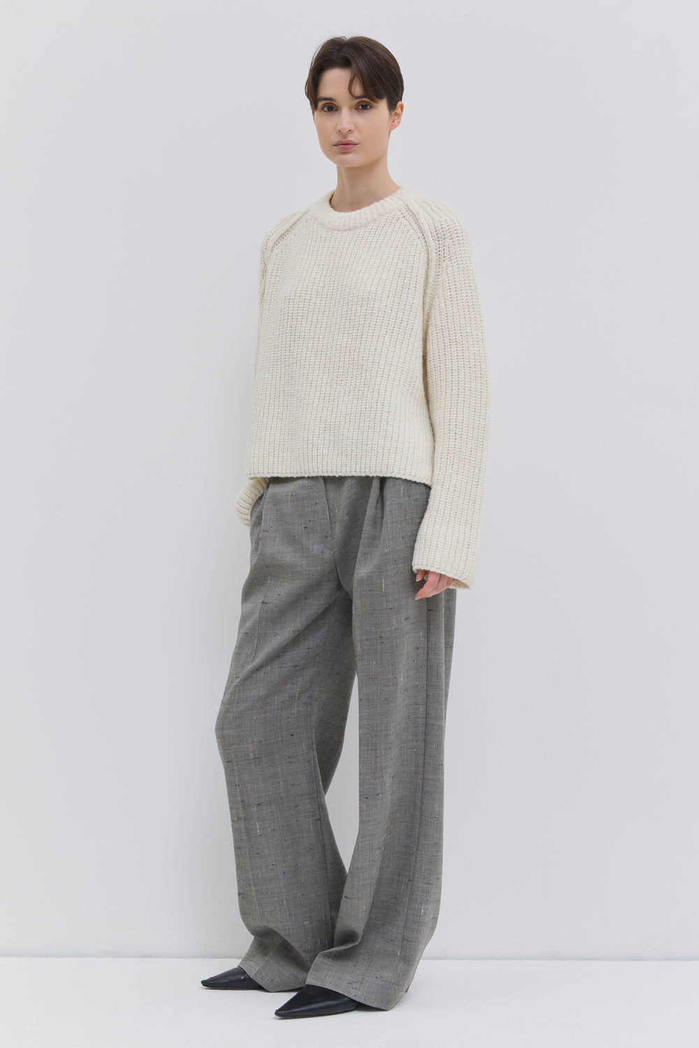 Three-quarter front view of the Pama wide-leg trousers in oat chartreux with front crease and tailored waistband.