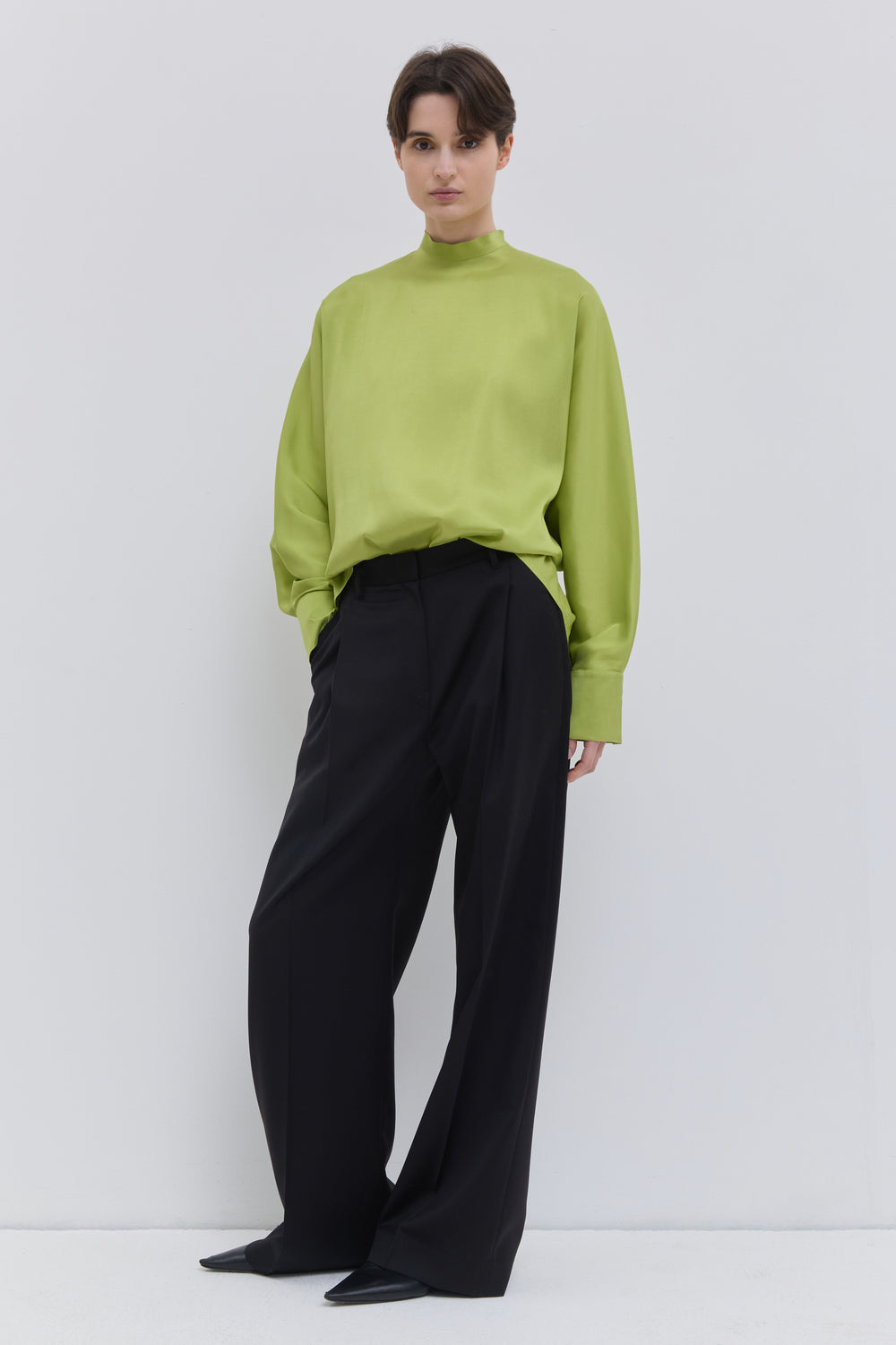 Black tailored trousers in 100% Italian wool featuring a wide-leg silhouette and pressed front crease by Christian Wijnants.