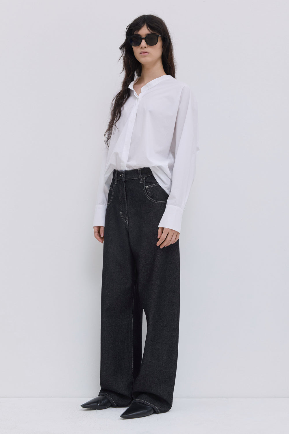Front view of dark raw denim wide-leg jeans with five-pocket construction.