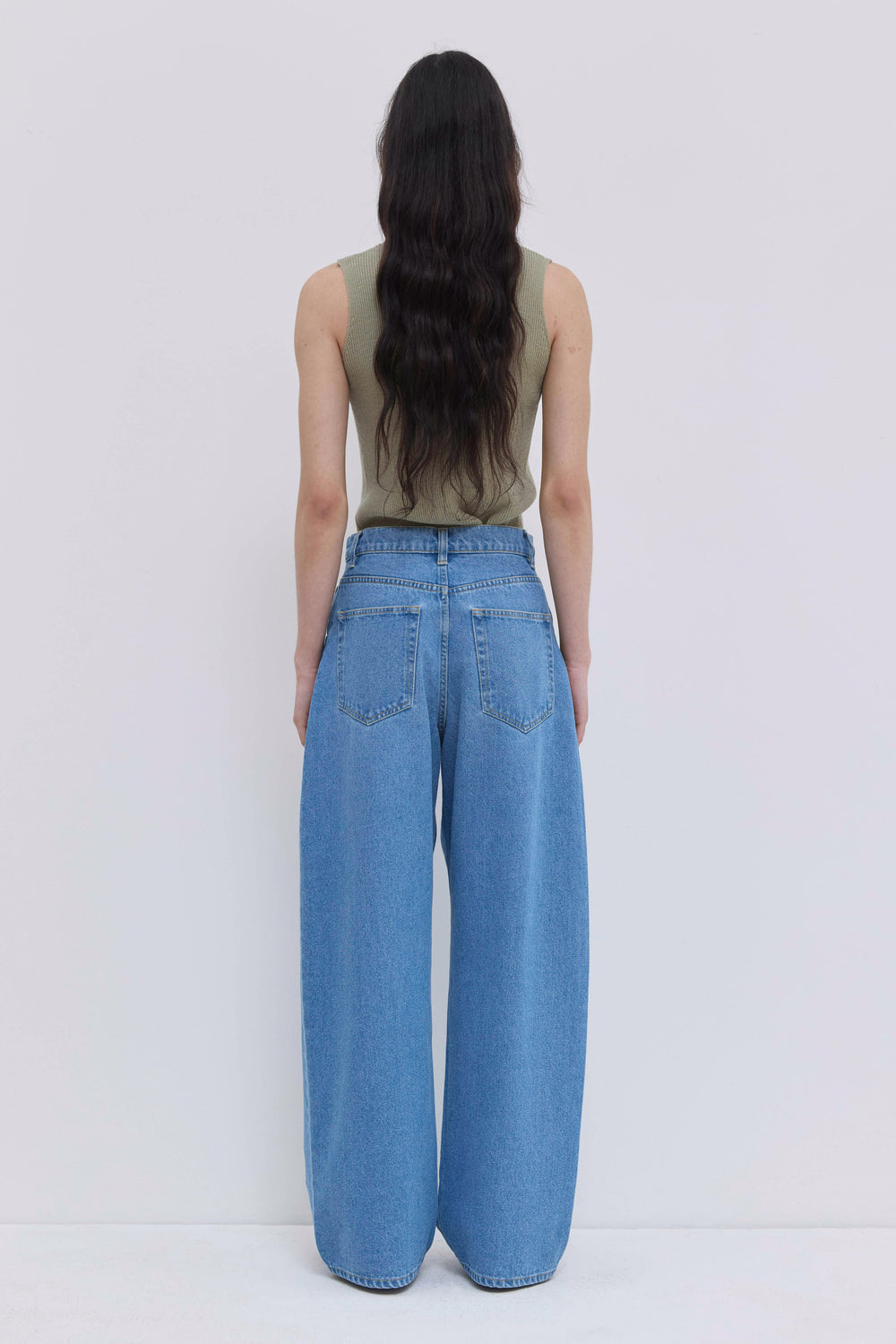 Back view of light blue washed denim jeans with a relaxed wide-leg silhouette.