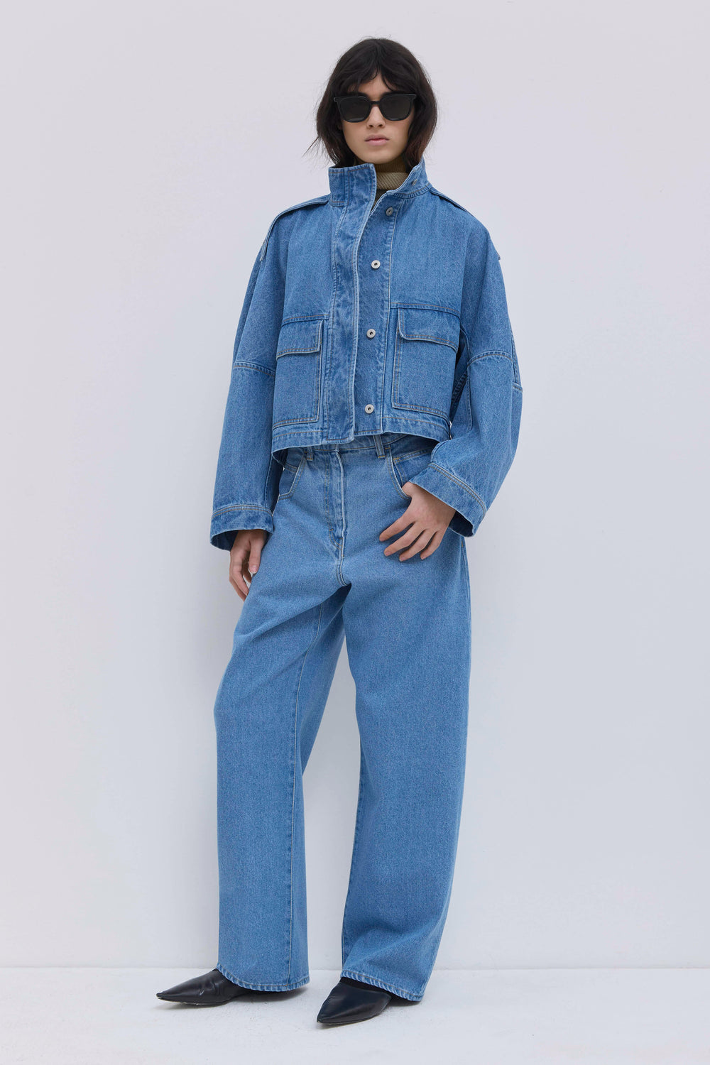 Light blue washed denim jeans paired with a cropped denim jacket.