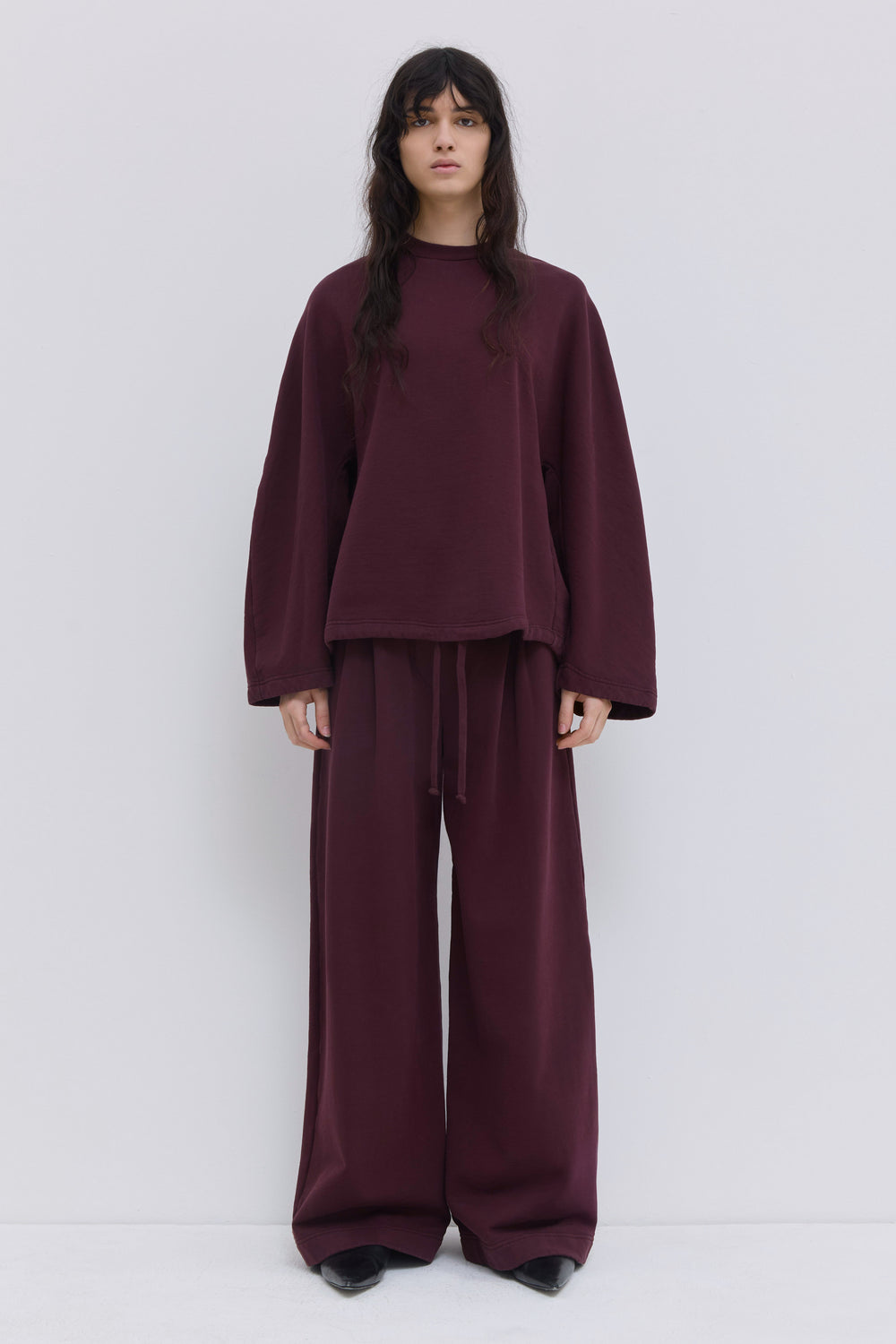 Wide-leg burgundy jersey trousers with an elasticated waistband.