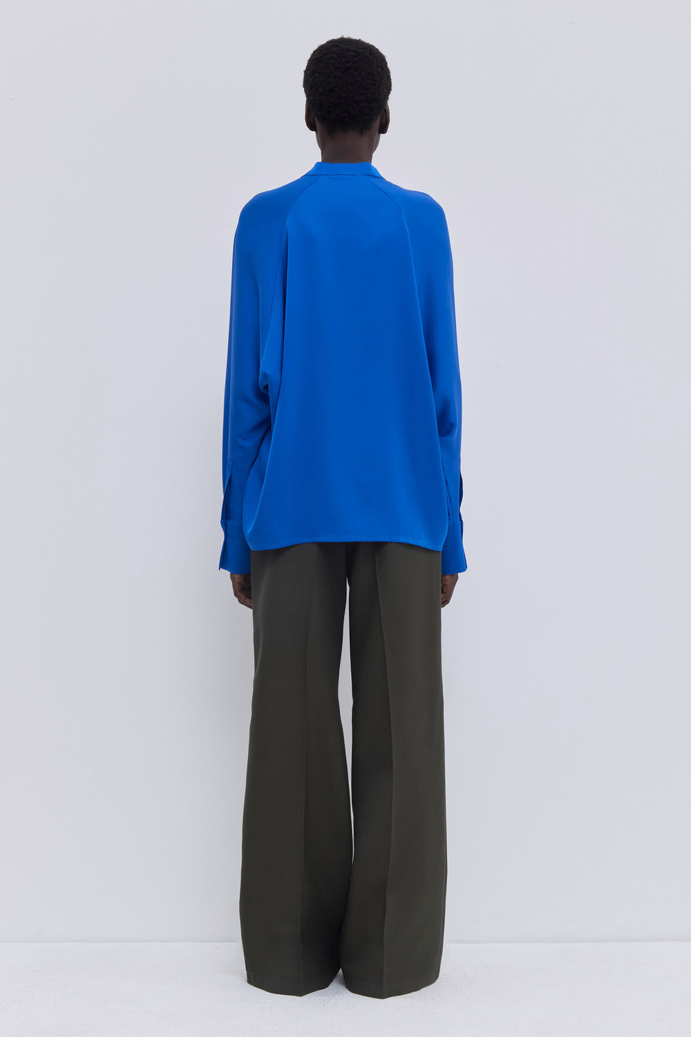 Back view of dark forest elastic waist wool trousers.