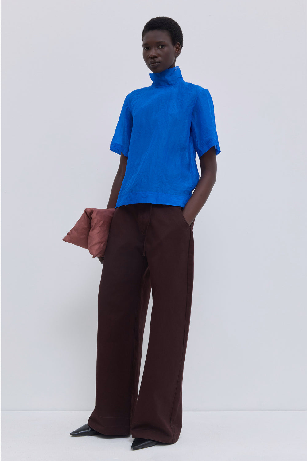 Back view of the Tapulo high-neck top in cobalt silk organza featuring a button closure and handcrafted crinkled finish.
