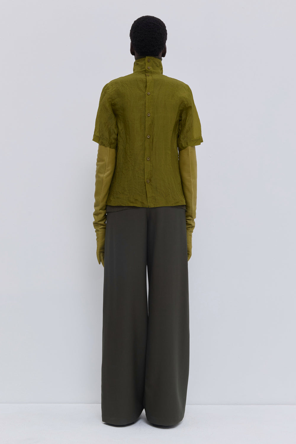 Back view of the Tapulo high-neck top in olive silk organza featuring a button closure and handcrafted crinkled finish.