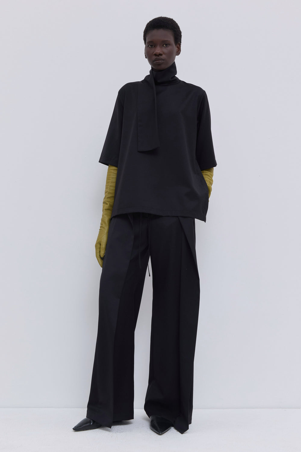 Black designer top with wide sleeves and soft scarf collar